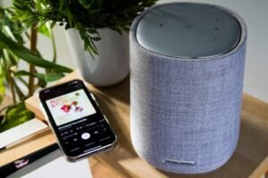 Bluetooth speaker and smartphone playing music on a table indoors.